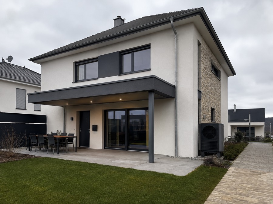Pompe à chaleur installée devant une maison contemporaine